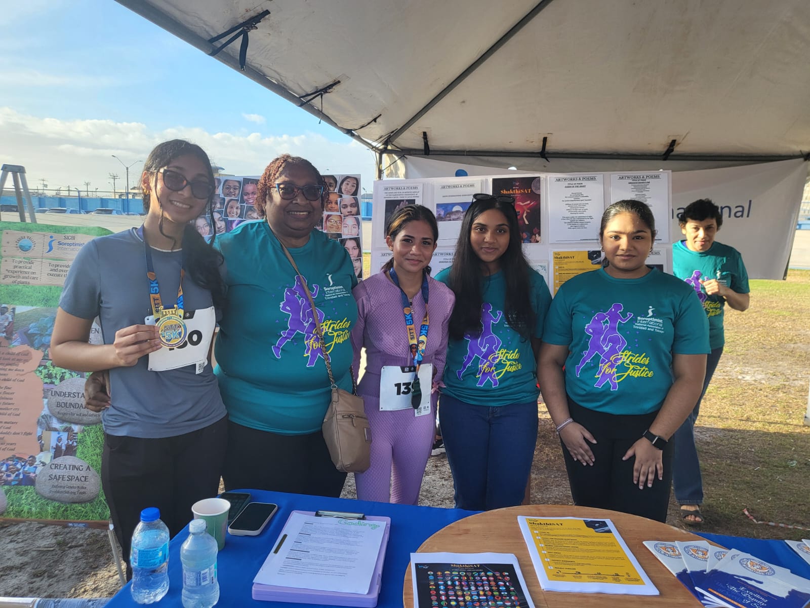 Finishers and cadets with medals at the Strides for Justice 5K booth